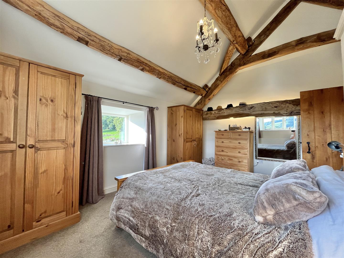 First-floor bedroom with a vaulted ceiling and exposed beams