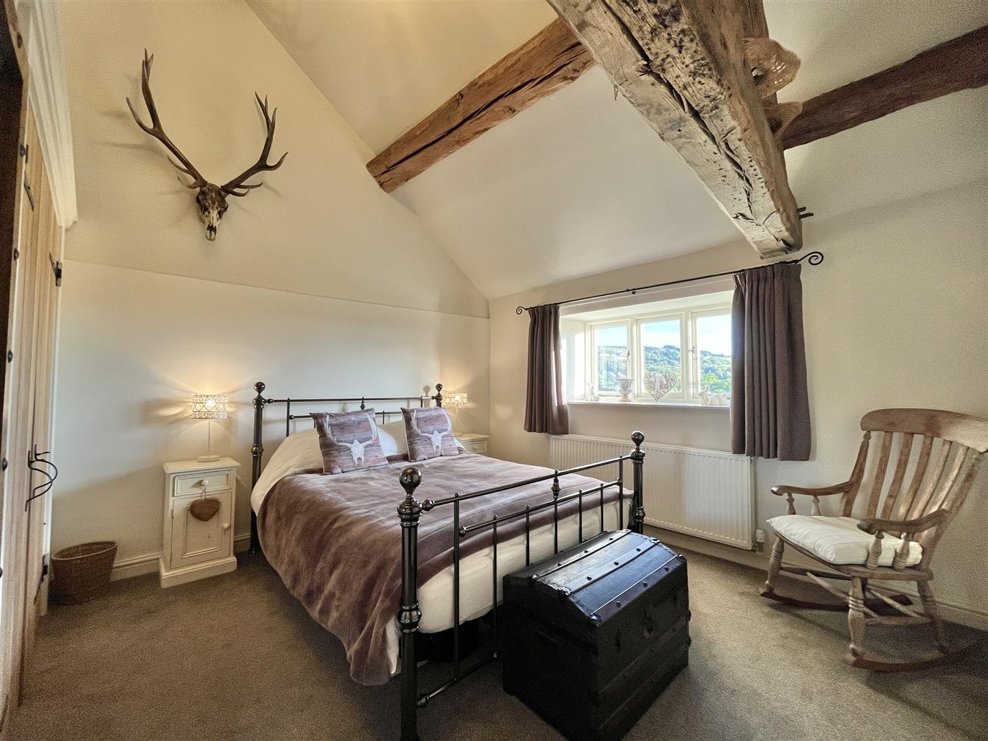 A vaulted bedroom with exposed beams