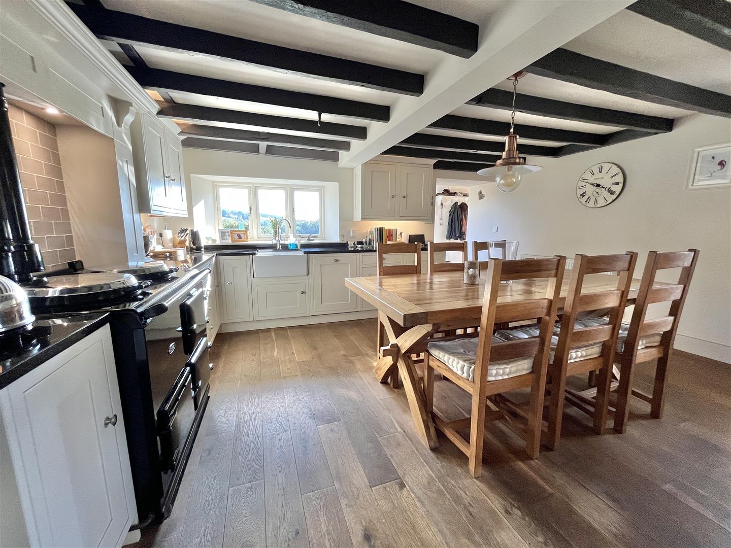 Two-oven AGA in its alcove with a farmhouse sink beneath the window
