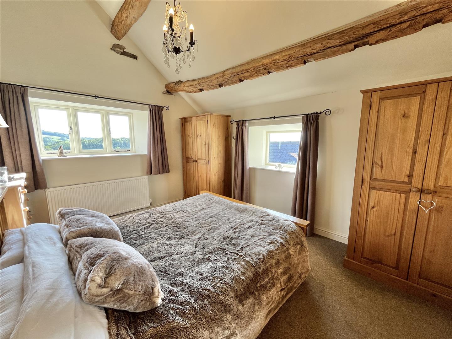 Main bedroom with a vaulted ceiling and exposed timbers