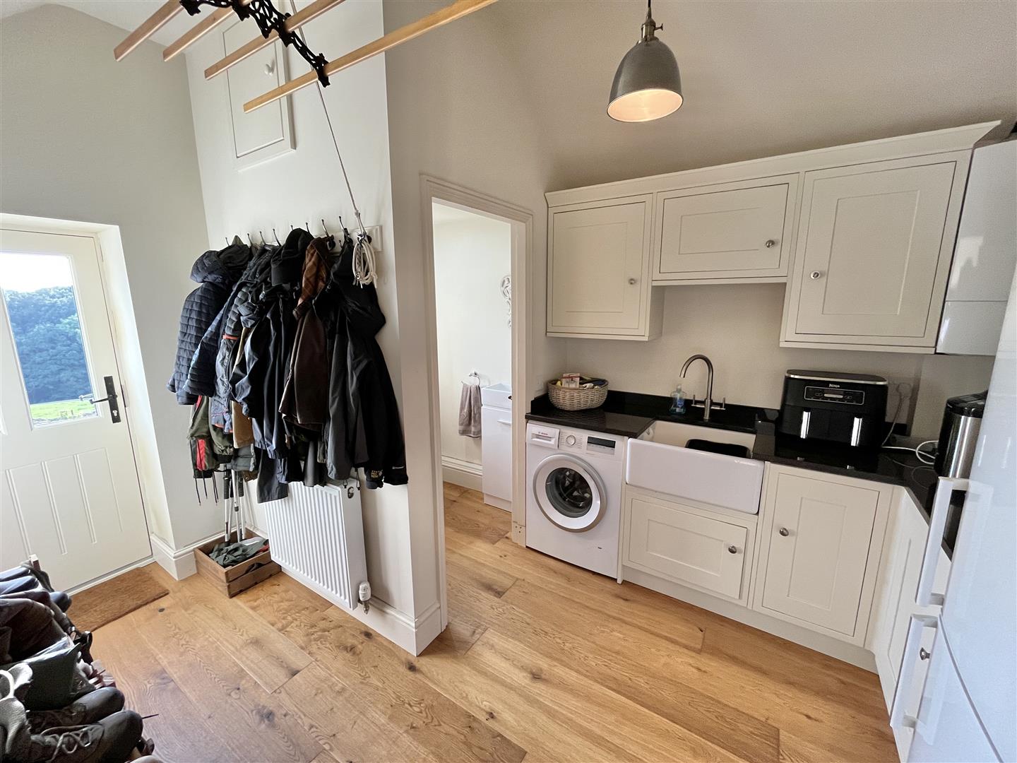 Boot and utility room with shaker cabinets, coat hooks and a pulley drying rack