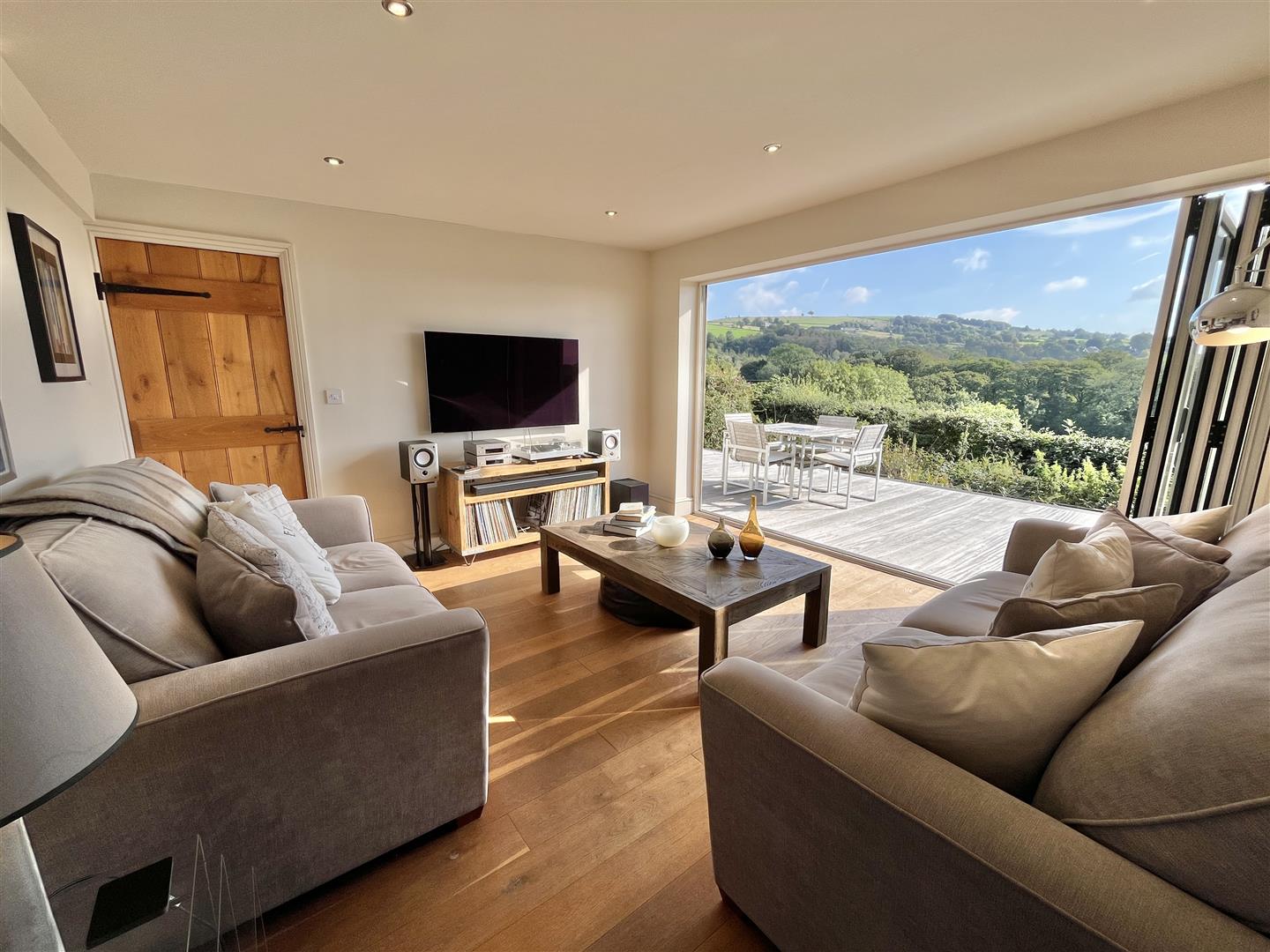 Bi-fold doors in the sunroom framing a panoramic valley view